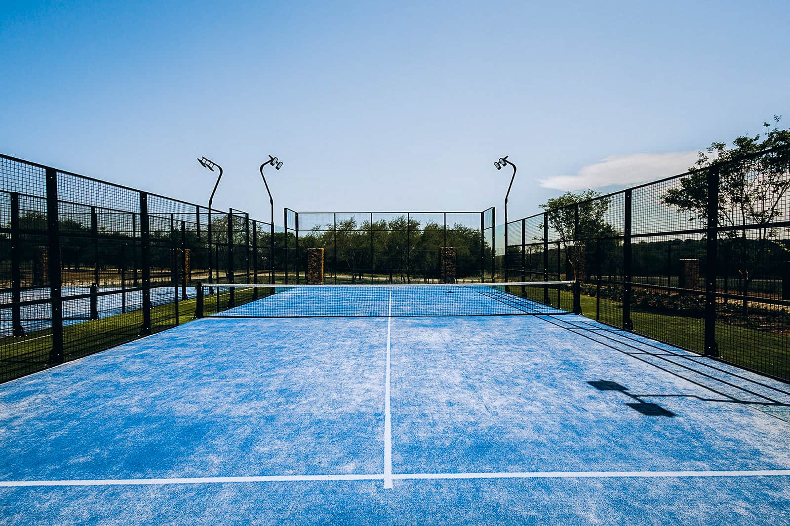 A blue outdoor padel court in the sunshine